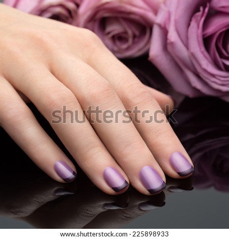 Beautiful manicure, polish is a violet color. Flower background.