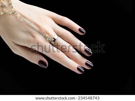 Manicured Nail with Black Matte Nail Polish. Manicure with Dark Nailpolish isolated on Black Background.