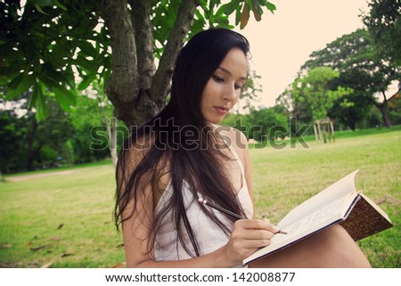 Girl at the park writes in her personal diary