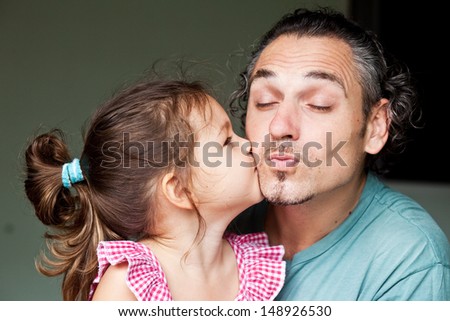 Daughter kissing her father on the cheek