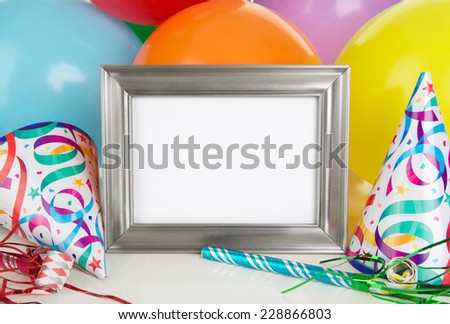 Empty Silver Photo Frame with Birthday Party Decorations including balloons,party hats and noisemakers