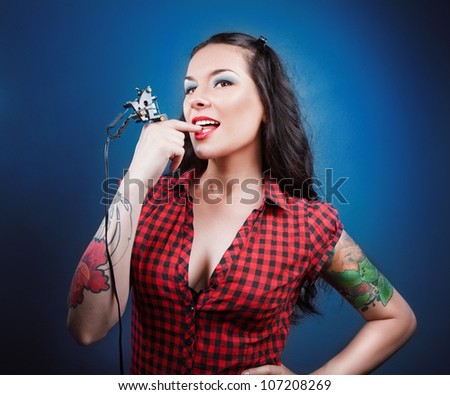Photo of beautiful girl with tattoos and tattoo machine.tattoos.