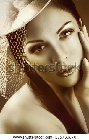 Face of young beautiful woman in a vintage hat. vintage.sepia tone