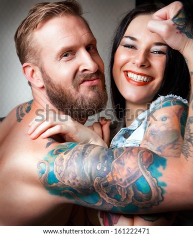 Sexy Couple with tattoos laughing together.