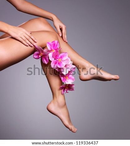 Beautiful long female legs with flower. Beauty treatment concept