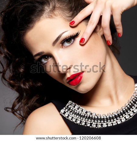 Beauty Fashion Woman With Red Nails, Lips And Golden Eye Makeup - On Black Background