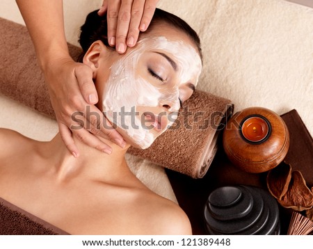 Spa Massage For Young Woman With Facial Mask On Face - Indoors