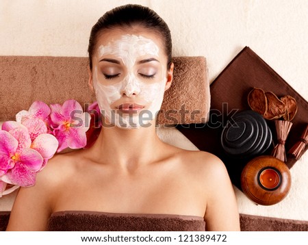 Young woman relaxing with cosmetic mask on face at beauty salon- indoors Young woman relaxing with cosmetic mask on face at beauty salon- indoors