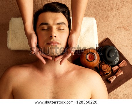 Masseur doing head massage on man in the spa salon Masseur doing head massage on man in the spa salon