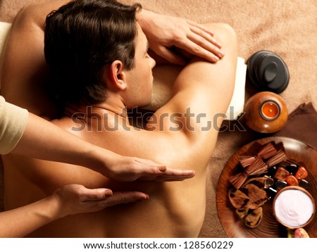 Masseur doing massage on man body in the spa salon Beauty treatment concept Masseur doing massage on man body in the spa salon Beauty treatment concept