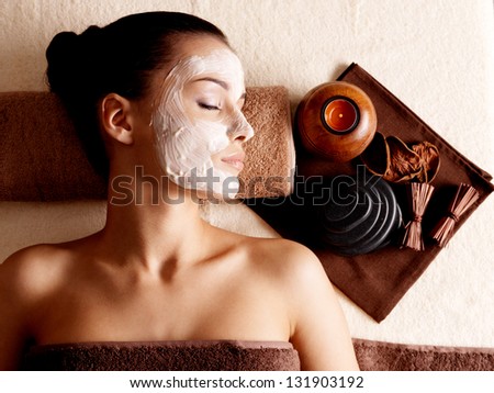 Young woman relaxing with facial mask on face at beauty salon- indoors Young woman relaxing with facial mask on face at beauty salon- indoors