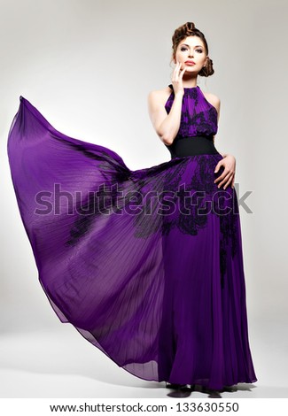 Beautiful fashion woman in purple long dress  hairstyle with pigtails design, poses at studio