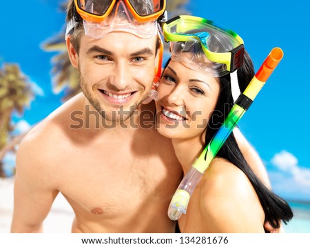Portrait of  happy fun beautiful couple  at tropical beach with swimming mask on face