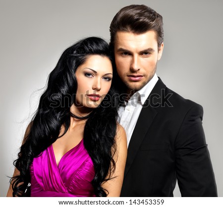 Portrait Of Young Couple In Love Posing At Studio Dressed In Classic Clothes