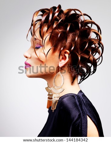 Profile portrait of the beautiful woman with fashion creative  hairstyle poses at studio.