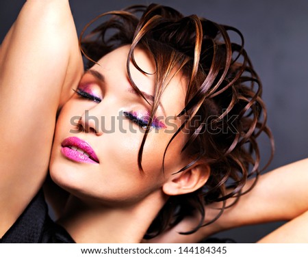 Beautiful saxy woman with bright pink makeup and stylish fashion hairstyle - posing at studio.