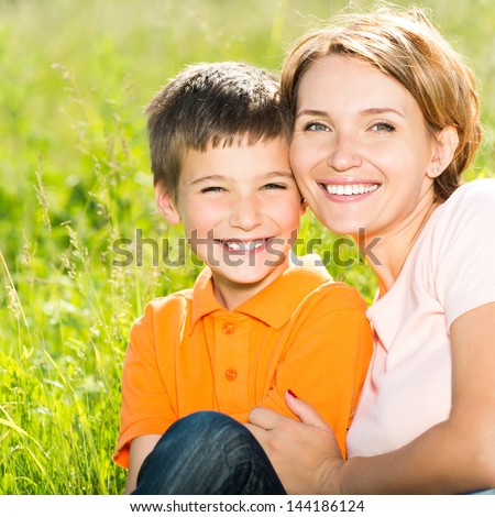 Happy Mother And Son In The Spring Meadow Outdoor Portrait