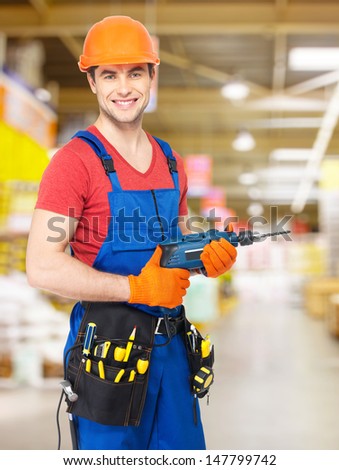 Portrait of smiling handyman with drill at   warehouse
