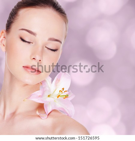 Beautiful Young Woman With Health Skin And Flower On Her Shoulder