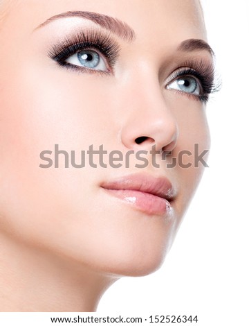 Closeup Portrait Of Young Beautiful White Woman With Long False Eyelashes Over White Background
