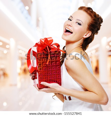 Happy Young Woman With Birthday Present In Hands Posing Indoors