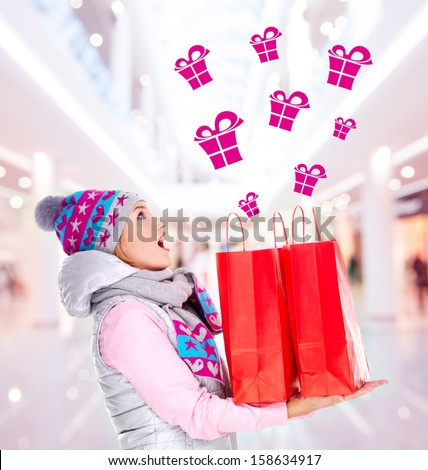 Photo of the surprised woman with gifts after shopping to the new year at shop