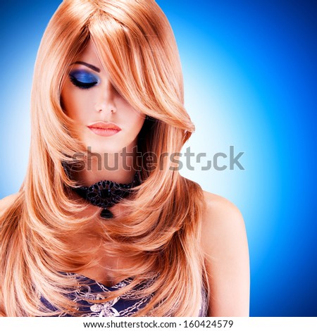 Beautiful Pretty Woman With Long Red Hairs. Portrait Of Young Fashion Model With Blue Eye Makeup Over Blue Background
