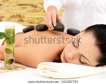 Woman Having Hot Stone Spa Massage Of Back In Beauty Salon