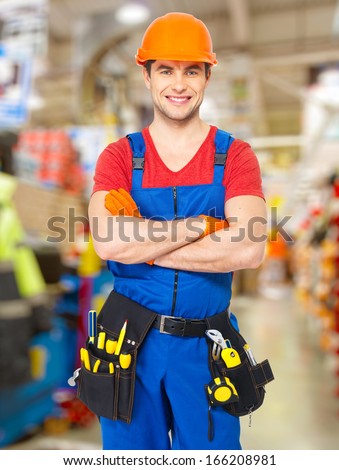 Portrait of smiling handyman stands at store