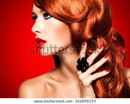 Beautiful sensual woman with long red hairs and red nails -  studio