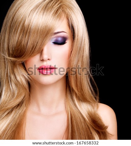 Closeup portrait of a beautiful young woman with long white hairs and red lips. Fashion model posing at studio over black background
