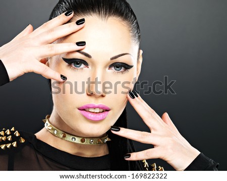 Beautiful face of fashion woman with black nails and bright makeup.  Sexy stylish girl with bracelet thorns on the neck