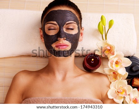 Adult woman relaxing in spa salon. Female face with cosmetic mask. Beauty treatment