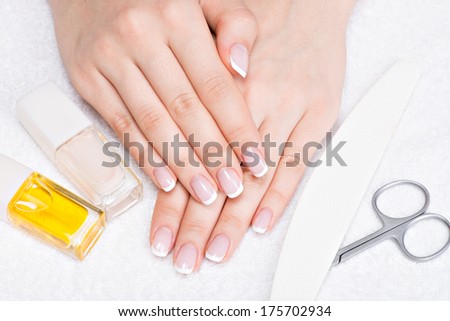 Woman in a nail salon receiving manicure by a beautician. Beauty treatment concept.