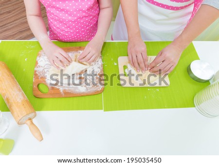 Mother and daughter molded cakes at the kitchen.