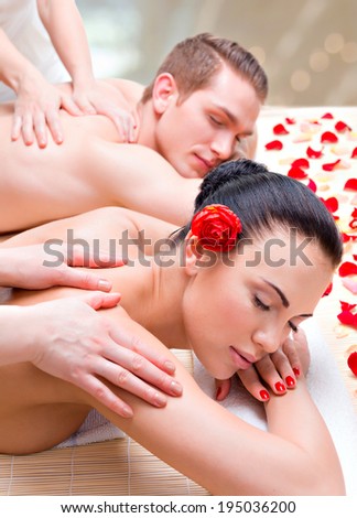Attractive couple lying  in a spa salon enjoying a deep tissue back massage together.