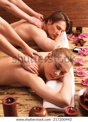 Attractive couple lying  in a spa salon enjoying a deep tissue back massage together.