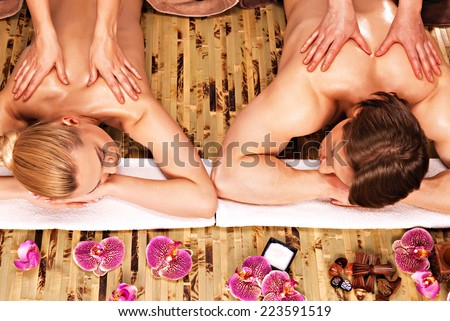 Beautiful couple getting deep back massage and relaxation at the spa salon.