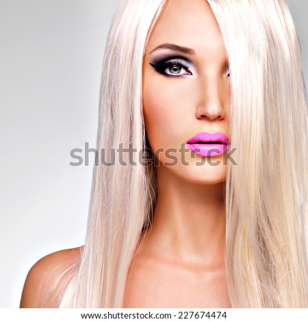 Portrait of  a  beautiful adult woman with long white straight  hairs.  Face of a Fashion model with pink lipstick. Pretty girl posing at studio.