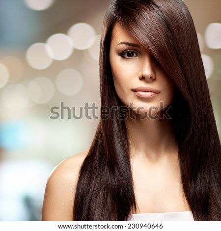 Beautiful woman with long straight brown hair. Fashion model posing at studio over art creative background