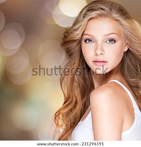 Portrait of beautiful  young woman with long curly hair. Closeup face of a pretty caucasian model looking at camera
