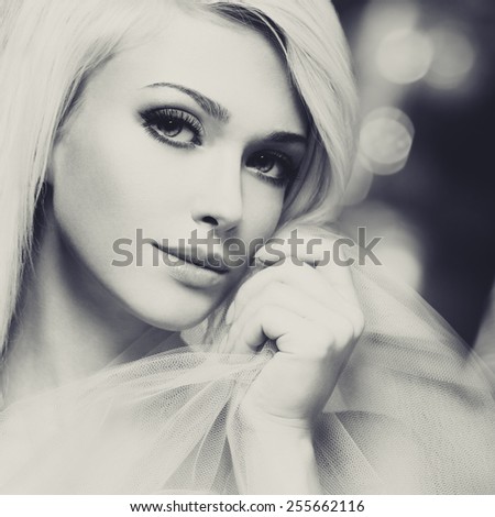 Close-up black and white portrait of sensual young woman touching her face creative background.