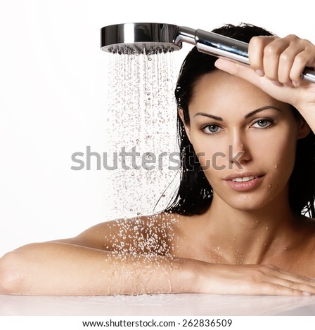 Portrait of a  beautiful brunette woman holds shower in hands  with falling water