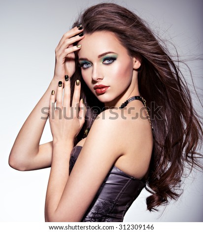 Beautiul woman with long brown hairs and green make-up and   nails