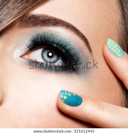woman\'s eye with turquoise makeup. Long false eyelashes. macro shot