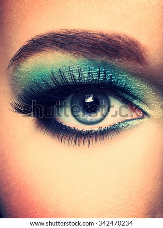 Woman's eye with green eye make-up. Long eyelashes