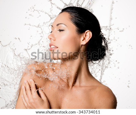 Beautiful naked woman with wet body and splashes of water