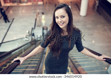Outdoor portrait of the beautiful young sexy woman. Attractive caucasian  girl smiling and posing in the shop. Pretty female person with positive emotions