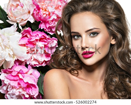 Beautiful face of young  woman over the pink flowers. Portrait of the pretty  healthy skin girl.