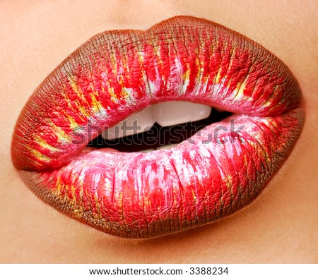 Multi colored lipstick with temptation gesture. Close-up lips. Macro shot.
